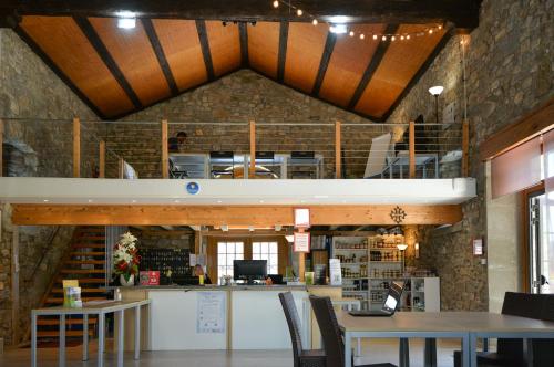 un bâtiment avec un loft avec des tables et des chaises dans l'établissement La Résidence du Château de Jouarres, à Azille