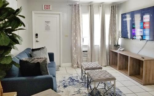 uma sala de estar com um sofá azul e uma televisão em Ultra Glam Apartment 5 Miles From Hard Rock Casino em Hollywood