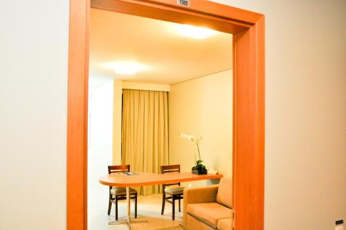 貝洛奧里藏特的住宿－西達德新星伊姆帕爾套房酒店，一间带桌椅和镜子的用餐室