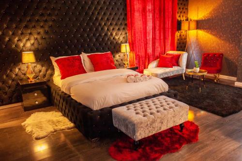 a bedroom with a large bed with red pillows at Opulent 1 Bedroom Cosy Suite in Birmingham