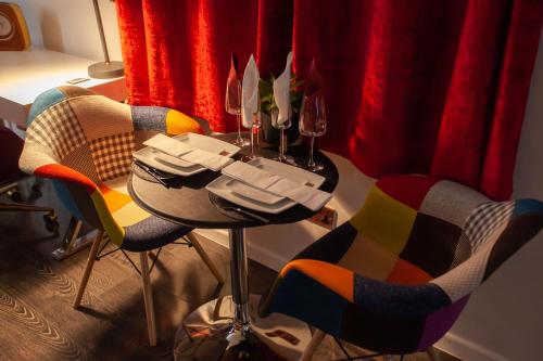 Opulent 1 Bedroom Cosy Suite في برمنغهام: طاولة مع كرسيين وكأسين للنبيذ