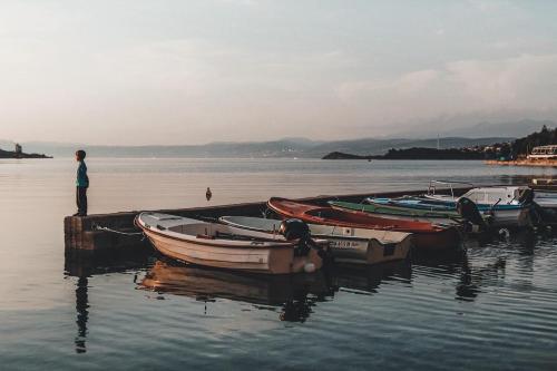 a man standing at a dock with boats in the water at ELA i GABI in Omišalj
