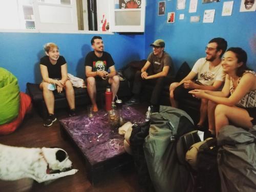 a group of people sitting in a room with a dog at Windmill Hostel in Mendoza