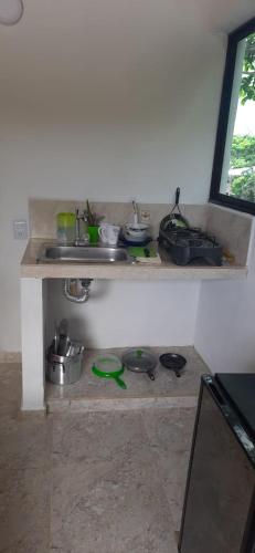 a kitchen with a counter with pots and pans at Cabañas El Olimpo in Necoclí