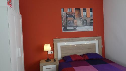 1 dormitorio con 1 cama y una pintura en la pared en Apartamento La Paz - Habitaciones con baño no compartido en pasillo en Oviedo