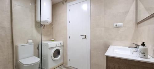 ein Badezimmer mit Waschmaschine und Waschbecken in der Unterkunft Homes of Spain, Apartamentos Paraíso, Ed Palmerston, Atico O, Suite con Piscina Privada en solárium, vistas al mar, a 50 m de la playa, WIFI in Playas de Vera