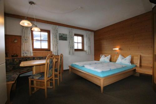 een slaapkamer met een bed, een bureau en een tafel bij Wimmers Hundsegghof WILD002 in Niederau