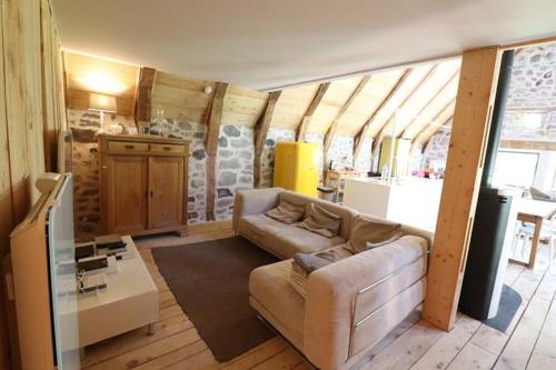 un salon avec un canapé et une table dans l'établissement La Grange Aux Frênes -Gîte 6 Personnes- Tranquillité, Nature et Confort, à Le Vaulmier