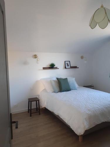 a white bedroom with a bed and a table at Les Verveines in Saint-Martin-dʼArdèche