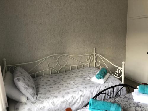 a bedroom with a white bed with blue pillows at 3br-Sleeps6-Garden-Mountain &near 4 Falls Walks on in Pont-Nedd-Fechan