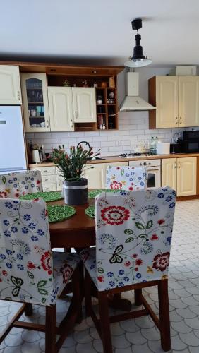 een keuken met een tafel en 2 stoelen met bloemen bij Sasaki Sauna i Bania in Szczutków
