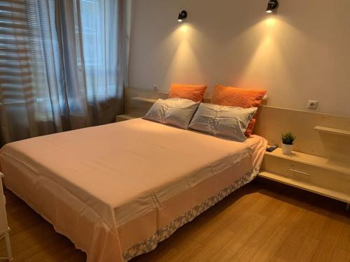 a bedroom with a large bed with orange pillows at Sliver city next to paradise mall and metro in Sofia
