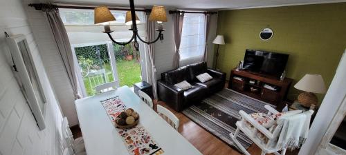 sala de estar con sofá y mesa en Prairie's House, en Temuco