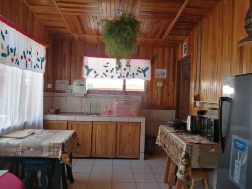 a kitchen with wooden walls and a kitchen with two tables at Pensión y Cabinas Colibrí B&B Costa Rica in Monteverde Costa Rica