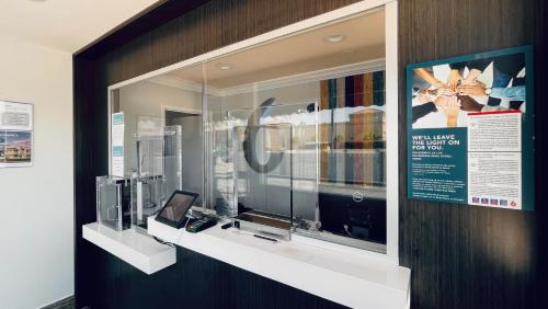 a display case in a building with a window with a television at Motel 6 Pico Rivera - Los Angeles, CA in Pico Rivera