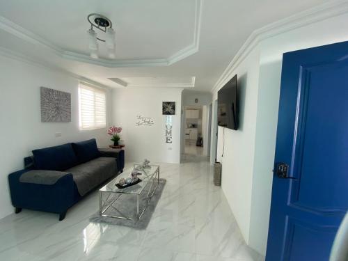 ein Wohnzimmer mit einem blauen Sofa und einem Tisch in der Unterkunft Salinas villa in La Libertad