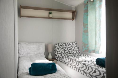 Habitación pequeña con 2 camas y ventana en 51 Lytchett Bay View, 3 bed, Rockley Park Poole, en Poole