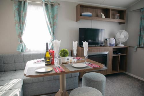 a living room with a table and a couch at 51 Lytchett Bay View, 3 bed, Rockley Park Poole in Poole