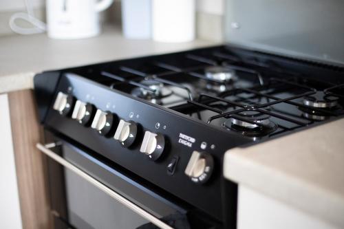 a black stove top oven in a kitchen at 51 Lytchett Bay View, 3 bed, Rockley Park Poole in Poole
