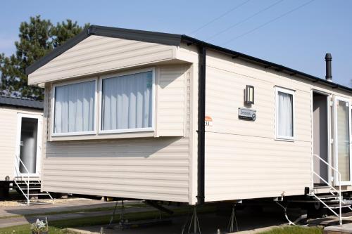 a white tiny house sitting on a trailer at 51 Lytchett Bay View, 3 bed, Rockley Park Poole in Poole