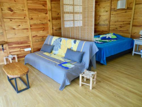 a living room with a couch and a bed at Fare Hanuatai in Tevaitoa