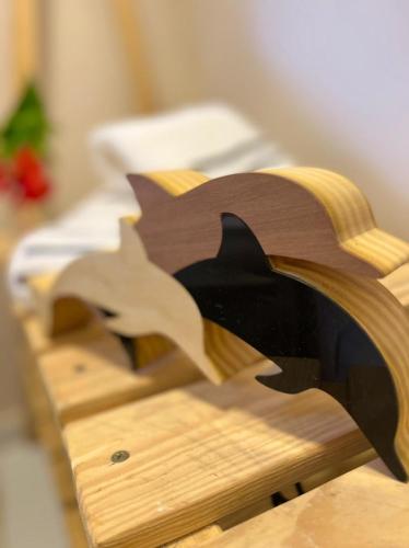 a wooden table with a dolphin carved into it at Pousada Maresia in Fernando de Noronha