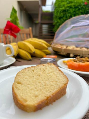 a piece of bread on a white plate on a table at Pousada Maresia in Fernando de Noronha
