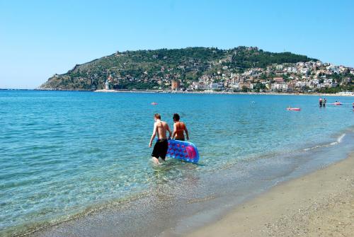two people standing in the water at the beach at Panorama Hotel - All Inclusive in Alanya