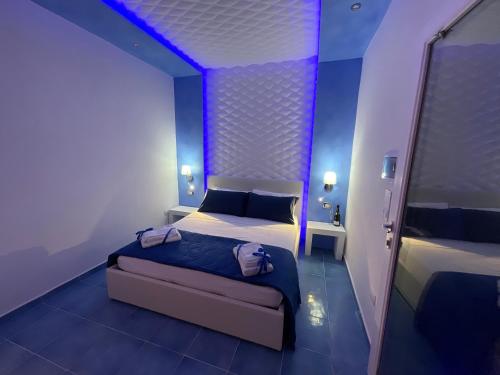 a bedroom with two beds with purple lights on the ceiling at Salento Sottovento Luxury BeB in Torre Lapillo