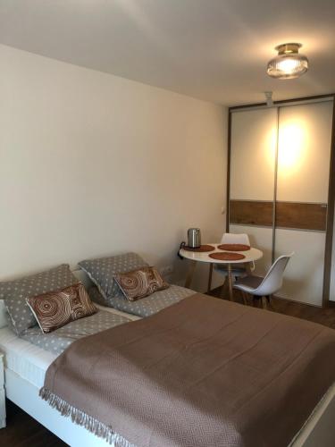 a bedroom with a large bed and a table at Maximo Apartments - free parking in Maribor