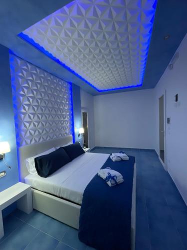 a bedroom with a bed with a blue led ceiling at Salento Sottovento Luxury BeB in Torre Lapillo