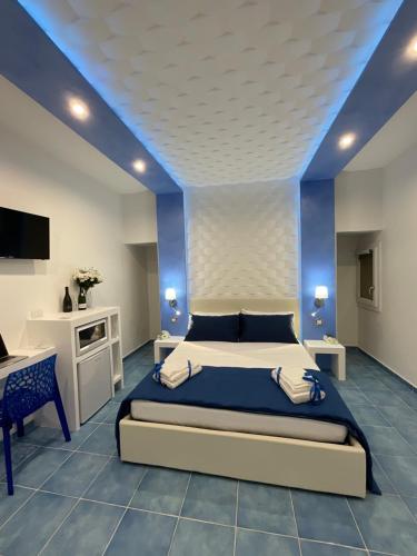 a bedroom with a bed and a blue ceiling at Salento Sottovento Luxury BeB in Torre Lapillo