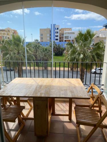 a wooden table on a balcony with a view of a street at Beach Apartment in Huelva