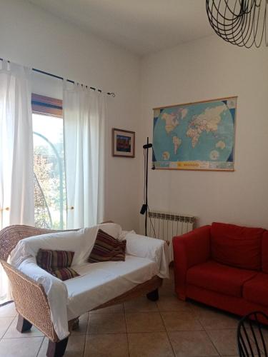 a living room with a white couch and a red chair at Il Poggio in Murlo