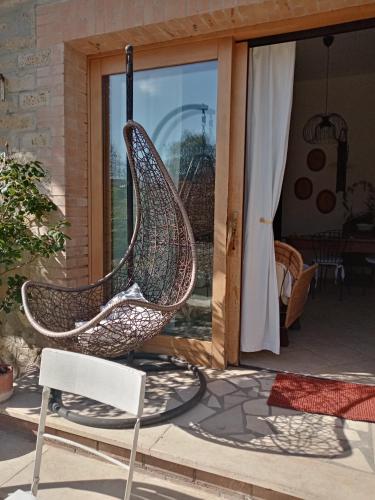 a swinging chair on a patio with a window at Il Poggio in Murlo