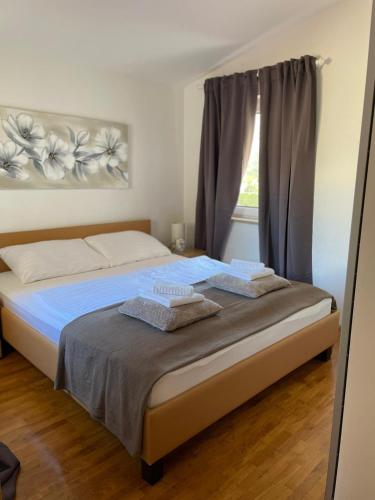 a bedroom with a bed with two towels on it at Apartman Rosi in Dramalj