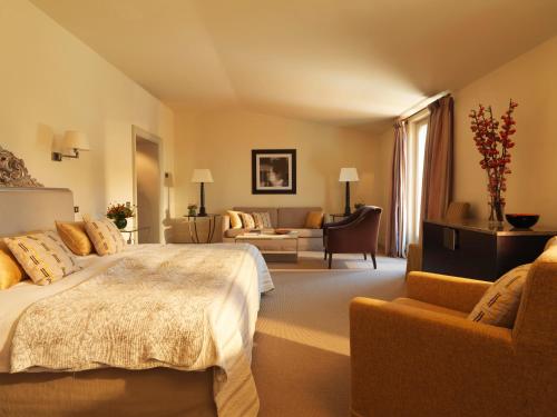a bedroom with a bed and a living room with a couch at Rocco Forte Hotel De Russie in Rome