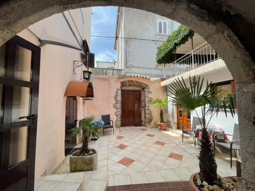 une arche d'un bâtiment avec une cour ornée de plantes en pot dans l'établissement Casa di Nives, à Krk