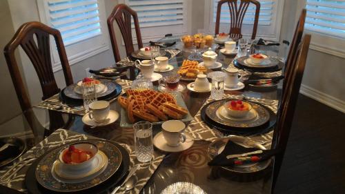een lange tafel met eten erop en stoelen bij Blue Skies Bed & Breakfast in Niagara on the Lake