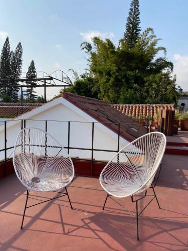two white chairs sitting on top of a roof at Casi Casa in Antigua Guatemala