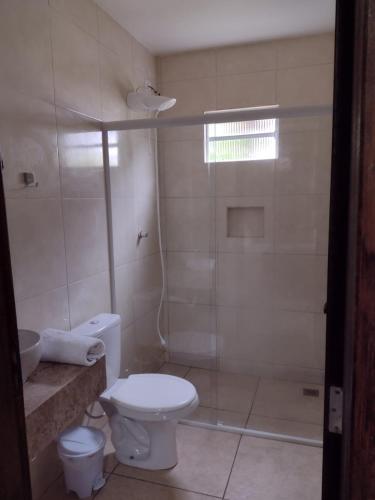 a bathroom with a toilet and a shower at Armazém do Porto Chalé Ixora in Morretes