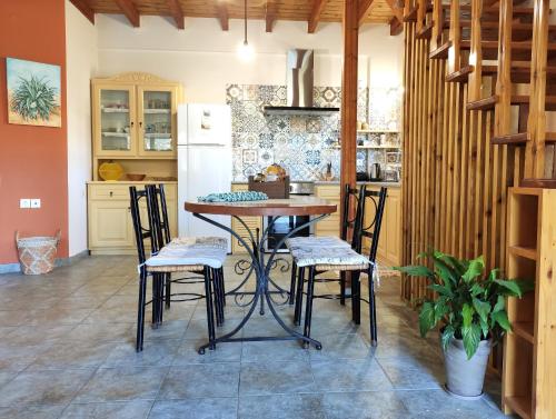 a kitchen with a table and chairs and a refrigerator at Villa Loula google it in Lygia
