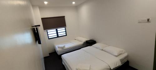 a bedroom with two beds and a window at Olive Bedz Hotel in Tambun