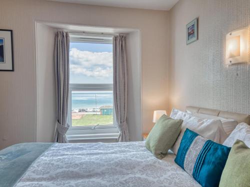 a bedroom with a bed and a large window at Apartment 5 - 1 Bedroom Sea Front-Sea Views-Free Parking in Paignton