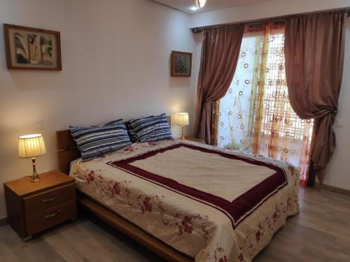 a bedroom with a large bed and a window at La Marina Luxury Apartment Fully Furnished Free WiFi, High Standard Residence, Swimming Pool View, Amazing Prime Location Close to Restaurants, Transport, Beach in Salé