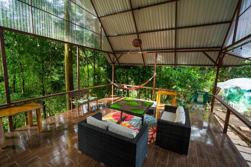 an outdoor living room with a table and chairs at Drake Bay River View in Drake