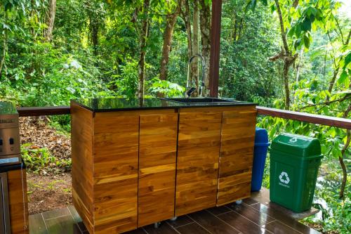 a wooden kitchen with a sink on a deck at Drake Bay River View in Drake