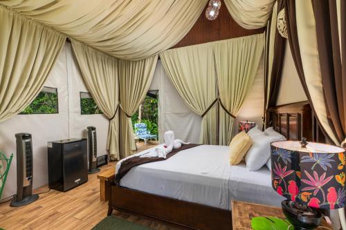 a bedroom with a bed in a room with curtains at Drake Bay River View in Drake