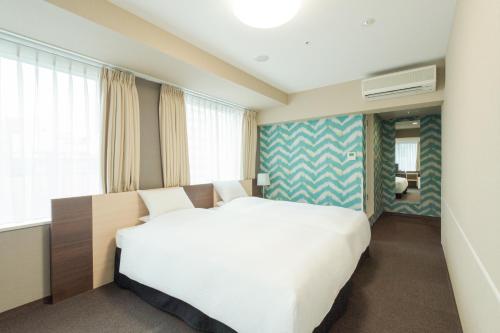 a bedroom with a large white bed in a room at Rose Stay Tokyo Shiba Park in Tokyo