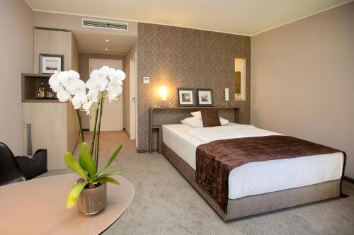 a hotel room with a bed and a table at Park Villa Hotel in Wuppertal